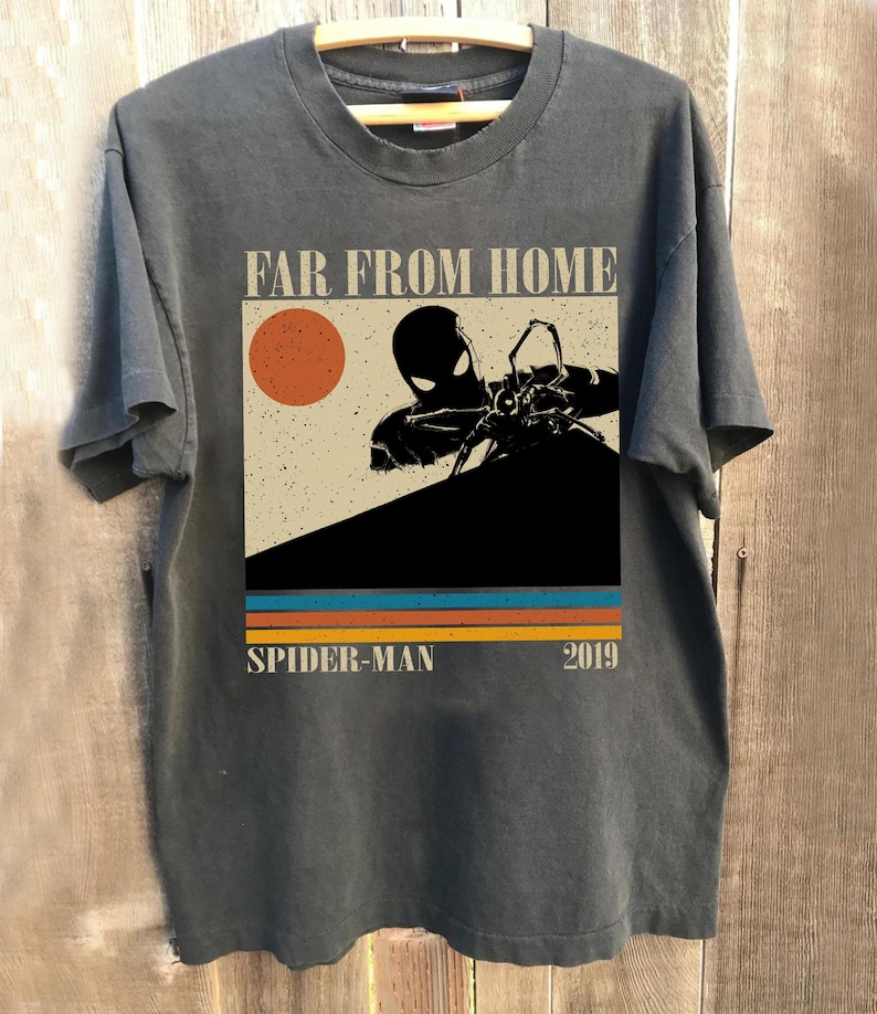 May include: Dark grey t-shirt with a graphic from the film "Spider-Man: Far From Home." The design features a silhouette of Spider-Man, a red sun, and the text "SPIDER-MAN 2019" in a retro style.