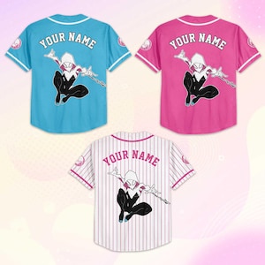May include: Three baseball jerseys in blue, pink, and white with a superhero graphic. Each jersey has the text "YOUR NAME" on the back. The blue and pink jerseys have a solid color, while the white jersey has vertical stripes.
