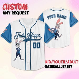 May include: White baseball jersey with blue sleeves and trim. Features the name "Judy Hopps" and the number "00" on the front. The back has "YOUR NAME" printed above a cartoon character. The text "CUSTOM ANY REQUEST" is at the top.