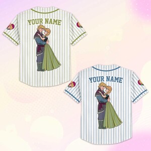 Puede incluir: Dos camisetas de b&eacute;isbol, una crema y otra blanca, con rayas verticales. Cada camiseta presenta una imagen de dibujos animados de una pareja abraz&aacute;ndose y el texto "YOUR NAME" en la espalda. Las mangas tienen un parche con un dise&ntilde;o de personaje.
