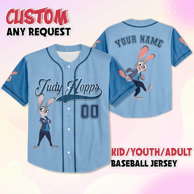 May include: Pale blue baseball jersey with the character Judy Hopps from Zootropolis. The jersey has "Judy Hopps" and the number "00" on the front. The back says "YOUR NAME". The sleeves are dark blue. The text "CUSTOM ANY REQUEST" is at the top.