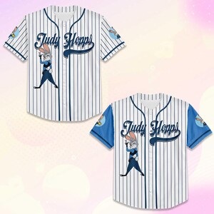 May include: Two white baseball jerseys with blue pinstripes. Each jersey features the name "Judy Hopps" in navy blue script and an illustration of a cartoon rabbit. One jersey has blue sleeves.