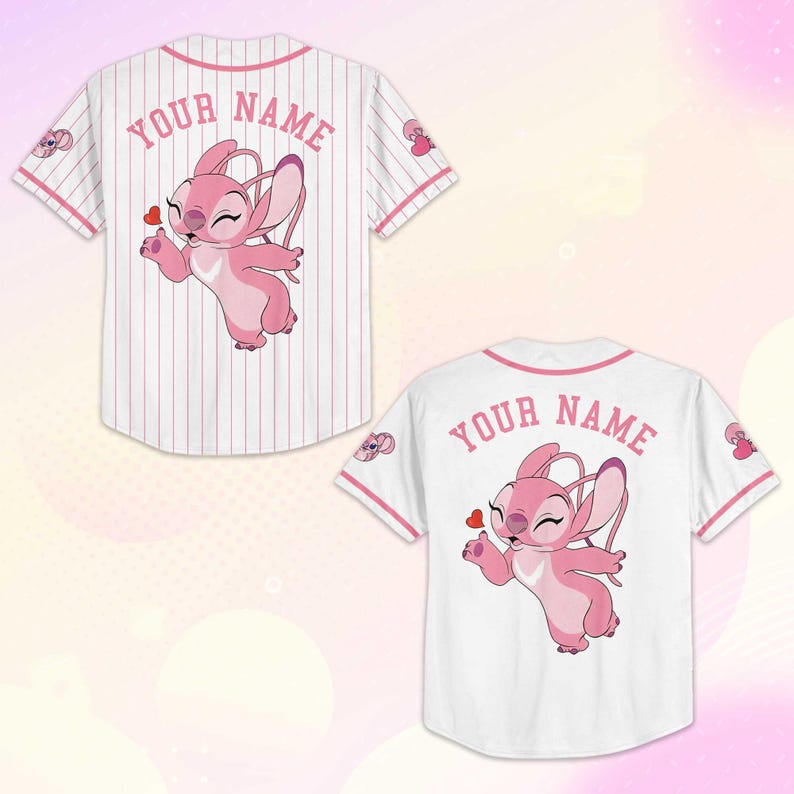 Peut inclure: Deux maillots de baseball, un &agrave; rayures et un blanc uni, pr&eacute;sentent un personnage de dessin anim&eacute; rose tenant un c&oelig;ur. Le texte "YOUR NAME" est arqu&eacute; au-dessus du personnage au dos de chaque maillot. Des accents roses ornent le col et les manches.
