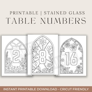 May include: Printable stained glass table numbers featuring the numbers 2, 8, and 16. Each number is displayed within a decorative arched window frame, surrounded by floral and leaf designs. The text at the top reads "PRINTABLE | STAINED GLASS TABLE NUMBERS".