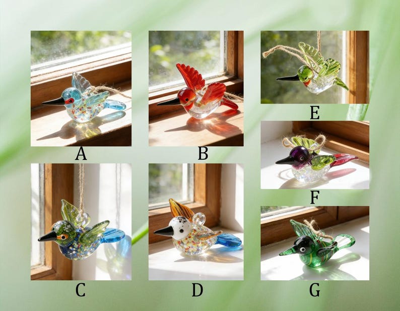 Op de afbeelding: Een verzameling glazen kolibrie-ornamenten in verschillende kleuren. Elke vogel heeft een lange snavel en uitgespreide vleugels, met details in blauw, rood, groen en geel. Sommige zijn opgehangen met touw.