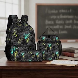 Pode incluir: Um conjunto escolar de três peças composto por uma mochila, uma lancheira e um estojo. Cada item apresenta um fundo cinza escuro com um padrão abstrato e caótico de linhas pretas, detalhes em amarelo neon e faixas em azul ciano vibrante.