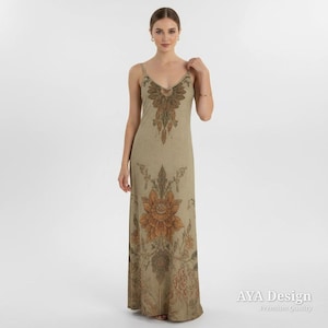 Puede incluir: Un vestido largo beige con un dise&ntilde;o floral. El vestido tiene tirantes finos y un escote en V. El estampado floral es en tonos marrones y naranjas. El vestido es largo hasta el suelo y tiene un corte holgado.