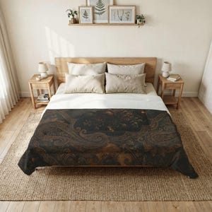May include: A bed with a wooden headboard and nightstands. The bed is covered with a white sheet and pillows. A dark comforter with a paisley design in shades of brown and black is draped over the bed.