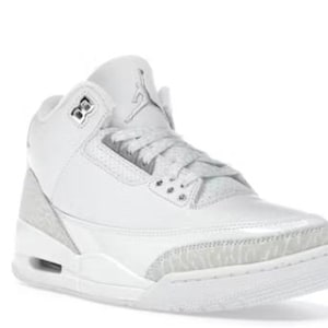May include: White high-top sneaker with a textured heel and toe cap. The shoe features a padded collar, a lace-up closure, and the iconic Jumpman logo on the tongue. The sneaker has a visible air pocket in the midsole.