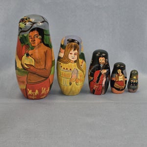 May include: A set of five hand-painted nesting dolls. The largest doll depicts a person holding a fruit, while the others feature figures with various designs. The dolls are painted with vibrant colors, including orange, red, and black.