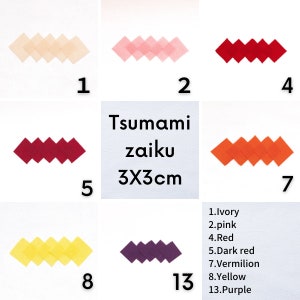 Könnte beinhalten: Ein Satz von 13 verschiedenen farbigen Origami-Papierquadraten, jedes mit einer Größe von 3x3 cm. Die Farben sind Elfenbein, Rosa, Rot, Dunkelrot, Zinnoberrot, Gelb und Lila. Das Papier ist in einer Reihe angeordnet, wobei jedes Quadrat zu einer Diamantenform gefaltet ist.