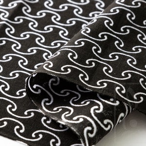 May include: Black fabric with a white repeating pattern of stylized waves.
