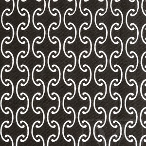 May include: A black and white fabric with a repeating pattern of interlocking circles. The circles are white and the background is black.