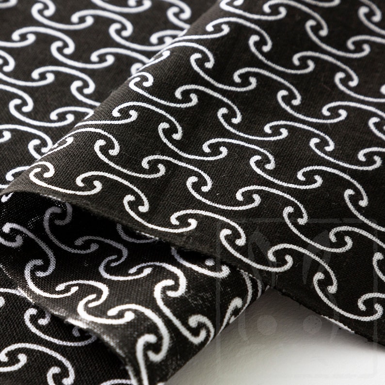 May include: Black fabric with a white wave pattern. The fabric is folded in half, showing the pattern on both sides.