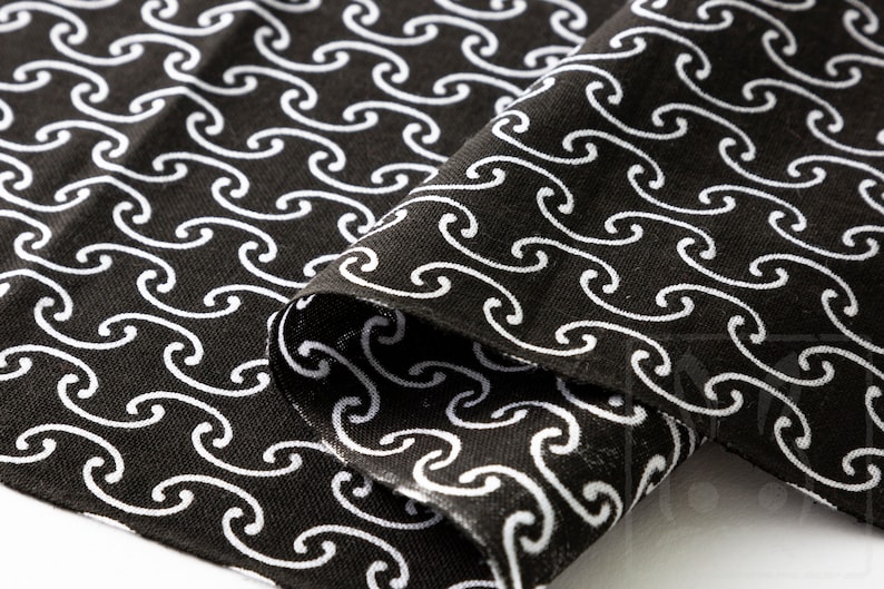 May include: Black fabric with a white wave pattern. The fabric is folded in half, showing the pattern on both sides.
