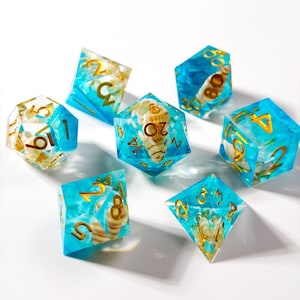 以下が含まれることがあります： 海をテーマにした7つの多面体サイコロのセット。各サイコロは、貝殻と金色の数字が埋め込まれた半透明のターコイズブルーです。テーブルトップロールプレイングゲーム用に設計されています。