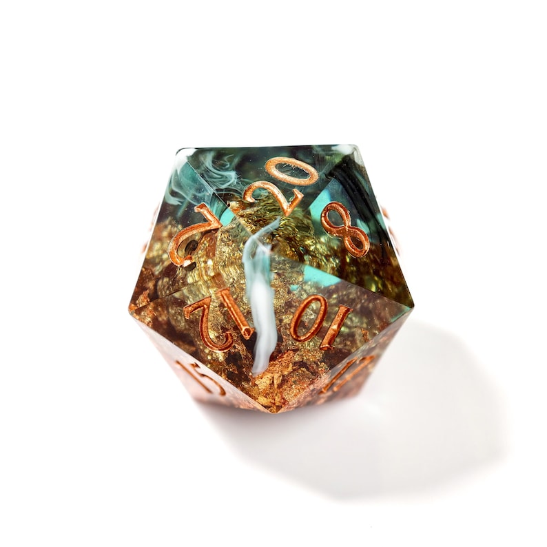 Op de afbeelding: Een twintigzijdige polyhedrale dobbelsteen met een uniek ontwerp. De dobbelsteen heeft een goud- en teal interieur met een wit waterval effect. De cijfers zijn koperkleurig. Geschikt voor tabletop rollenspellen.