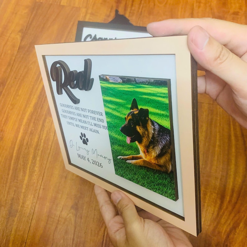 Puede incluir: Una placa conmemorativa rectangular de madera con marco de madera clara y fondo blanco. Muestra el nombre Red en letras 3D oscuras, una fotograf&iacute;a de un pastor alem&aacute;n sobre hierba, un icono de huella y la fecha MAY 4, 2026.