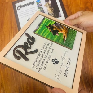 Puede incluir: Un marco conmemorativo cuadrado de madera con una fotograf&iacute;a de un perro pastor alem&aacute;n sobre hierba verde. El marco incluye el nombre Red en letras negras en relieve, el texto Goodbyes are not forever, un icono de huella y la fecha May 4, 2026.