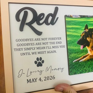 Puede incluir: Un marco de madera rectangular que contiene una placa conmemorativa con el nombre Red en letras negras en relieve. El texto dice: GOODBYES ARE NOT FOREVER GOODBYES ARE NOT THE END THEY SIMPLY MEAN I'LL MISS YOU UNTIL WE MEET AGAIN. Incluye una huella, In Loving Memory y MAY 4, 2026, junto a la foto de un perro pastor alem&aacute;n.