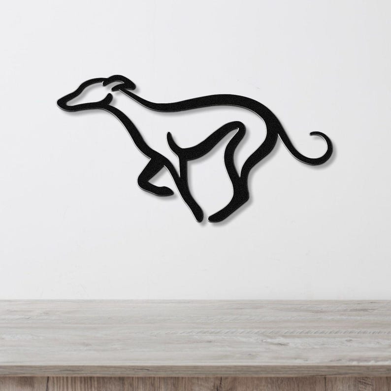 Black metal greyhound wall art with a minimalist silhouette design, mounted on a white wall above a light wood surface.