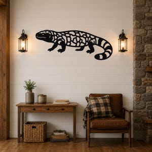 Black metal Gila monster wall art with intricate cutout patterns, mounted on a shiplap wall above a wooden console table in a living room.