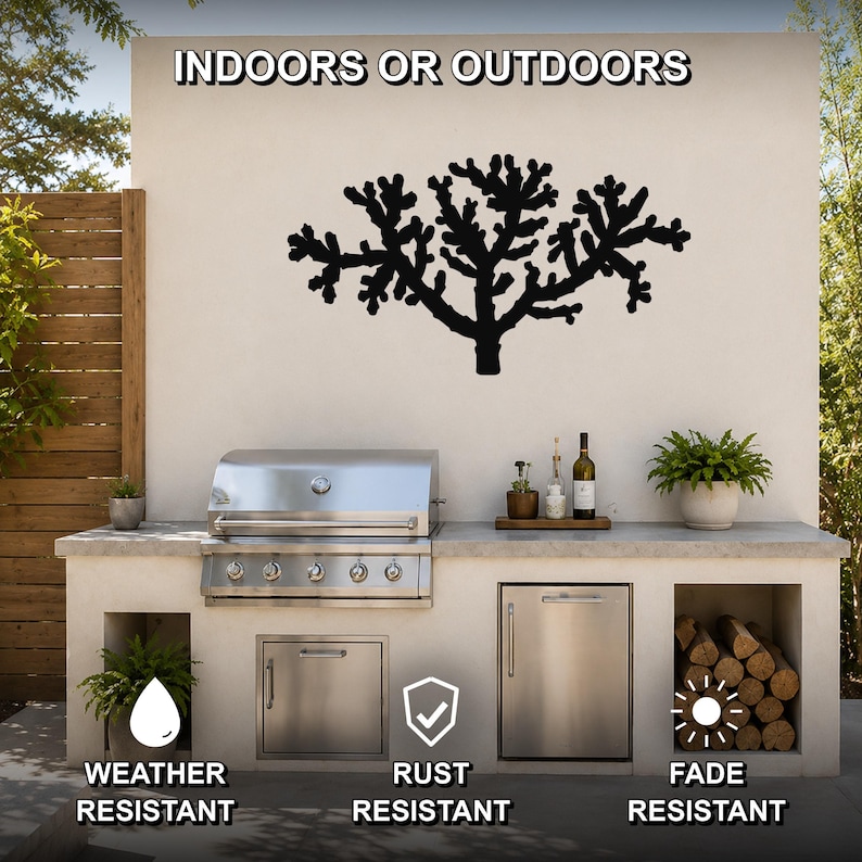 Black metal Cholla cactus wall art with branching cutout design, mounted on an outdoor kitchen wall above a stainless steel grill.