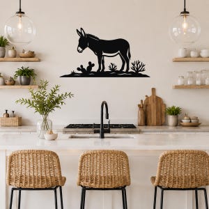 Black metal burro wall art silhouette with cactus and desert plants, mounted above a kitchen counter.
