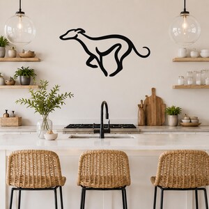 Black metal greyhound silhouette wall art with motion-line cutouts, mounted above a kitchen counter.