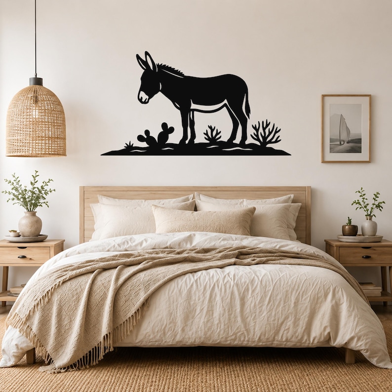 Black metal burro wall art silhouette with cactus and desert plants, mounted above a bed in a neutral bedroom.
