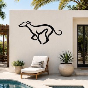 Black metal greyhound wall art silhouette mounted on an outdoor patio wall above a lounge chair, with palm trees and a pool in the background.