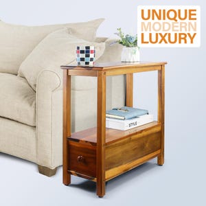 May include: A wooden side table with a drawer and a lower shelf. The table is a warm brown color and has a simple, modern design. A mug with a geometric pattern and a small vase with flowers sit on top. The text "UNIQUE MODERN LUXURY" is in the upper right corner.