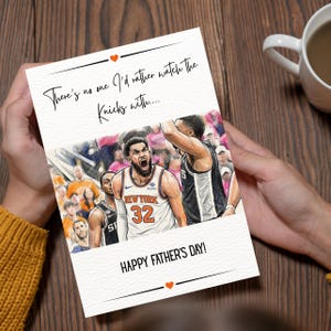 May include: A white greeting card featuring a basketball illustration of a player in a New York 32 jersey. The text reads, There's no one I'd rather watch The Knicks with.... and HAPPY FATHER'S DAY! with small orange heart icons above and below.