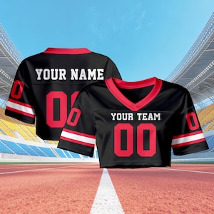 May include: Two black cropped football jerseys with red trim and white stripes. One jersey says "YOUR NAME" and has the number "00", the other says "YOUR TEAM" and has the number "00". The jerseys are on a running track.