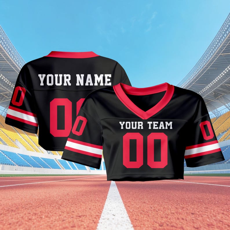 May include: Two black cropped football jerseys with red trim and white stripes. One jersey says "YOUR NAME" and has the number "00", the other says "YOUR TEAM" and has the number "00". The jerseys are on a running track.