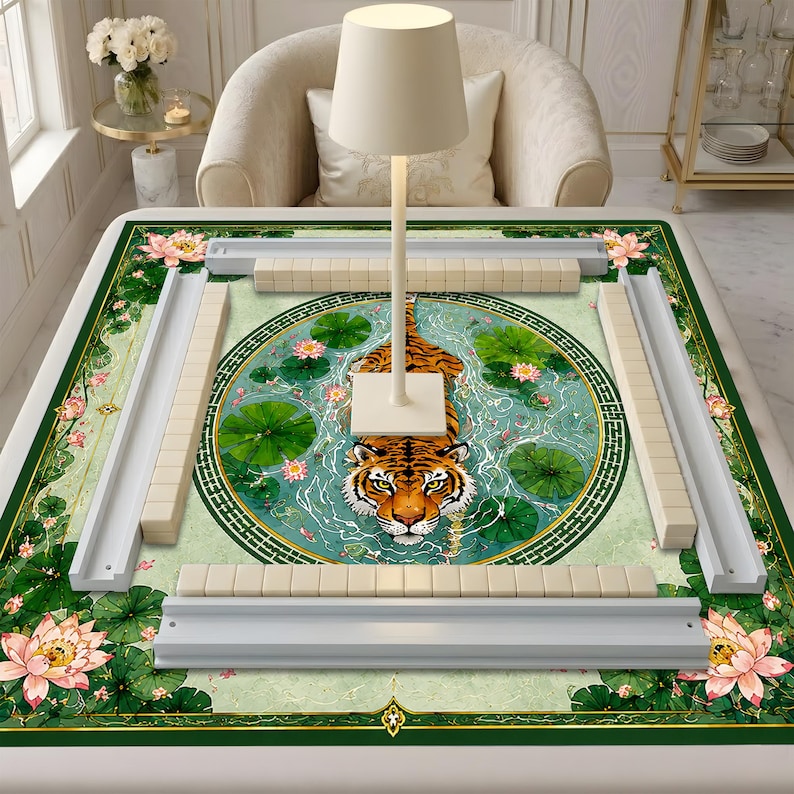May include: A rectangular mahjong mat featuring a central circular illustration of a tiger swimming in a pond with green lily pads and pink lotus flowers. The mat includes four white tile racks and a white lamp stand in the center.