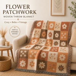 May include: A woven throw blanket with a flower patchwork design. The blanket features a grid pattern of squares in shades of brown, beige, and orange, each square adorned with floral motifs. The text "Flower Patchwork" and "Woven Throw Blanket" are visible.