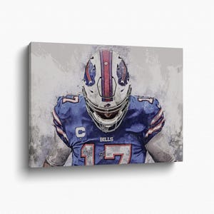Peut inclure: Impression sur toile d'un joueur de football américain en maillot bleu avec le numéro 17. Le joueur porte un casque blanc avec des rayures rouges et bleues. Le mot "BILLS" est visible.