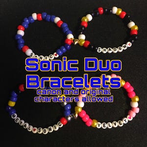May include: Four beaded bracelets in the image. The bracelets are blue, red, white, black, yellow, and pink. The bracelets have the words "SONIC", "SHADOW", "METALSONIC", and "VELVET" spelled out on them. The text "Sonic Duo Bracelets" is also in the image.