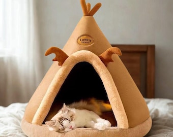 May include: A tan teepee-shaped cat bed with brown antler-like accents and a small logo that reads "Lucky Toyou". A cat with white and brown fur is sleeping inside the bed on a soft, plush interior.