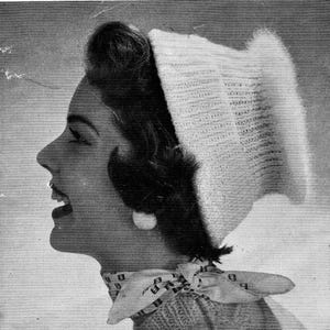 May include: A monochrome image of a woman wearing a white knitted hat with a fluffy trim. She is also wearing a patterned scarf and a large white earring. The woman is looking to the side with her mouth open.