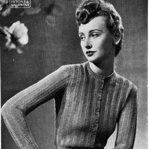 Könnte beinhalten: Schwarz-Weiß-Bild einer Frau in einem Strick-Cardigan. Der Cardigan hat ein vertikales Rippenmuster und einen Knopfverschluss. Die Ärmel sind lang und eng anliegend. Der Text "PATONS & BALDWINS" ist im Bild enthalten.