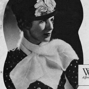 May include: A vintage black and white image of a woman wearing a hat with a large floral accent. She is also wearing a white scarf and a polka dot top. The image has a classic, elegant style.