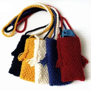 May include: A collection of five small, rectangular, crocheted pouches in black, yellow, white, blue, and red. Each pouch features a matching braided yarn strap and a small tassel on each side. A blue electronic device is tucked into the red pouch.