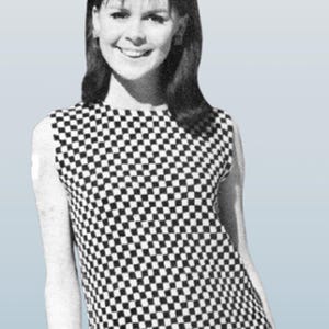 May include: A black and white checkered sleeveless top. The top is worn by a person with dark hair and a headband. The image is in black and white, with a light blue background.