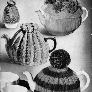Puede incluir: Imagen de Woman and Home, noviembre de 1951, con tres cubreteas de punto. Los cubreteas son de diferentes patrones y colores, uno con un pompón. La imagen también incluye un cubreevos y tazas de té.