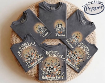 May include: A collection of charcoal gray t-shirts featuring various Disney character Halloween graphics. The designs include skeletons, castles, and the text Mickey's Not So Scary Halloween Party and Walt Disney World. The shirts are labeled Comfort Colors Pepper.