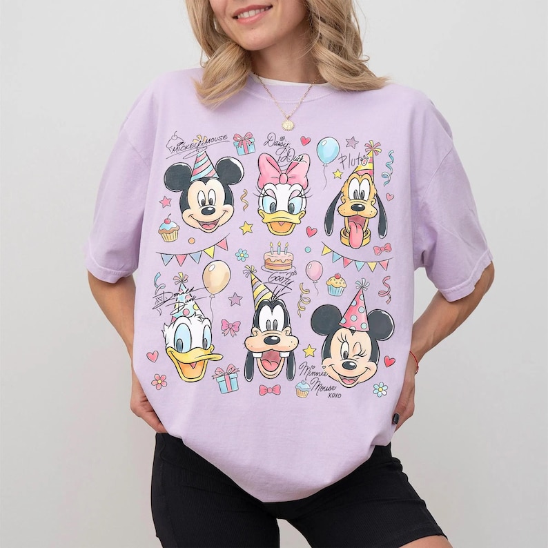 Puede incluir: Camiseta lila claro con un gr&aacute;fico colorido de Mickey Mouse, Daisy Duck, Donald Duck, Goofy, Pluto y Minnie Mouse, todos con sombreros de fiesta. El dise&ntilde;o incluye pastel de cumplea&ntilde;os, globos y confeti.