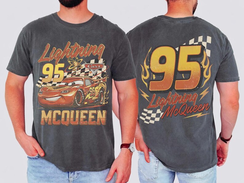 May include: Dark grey t-shirt featuring Lightning McQueen from the Cars film. The front graphic shows McQueen with the number 95 and the text "Lightning McQueen" and "Cars". The back has a large "95" with flames and the text "Lightning McQueen".