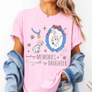 Op de afbeelding: Roze T-shirt met een Dalmatische print. Het ontwerp bevat een ingelijste afbeelding van twee Dalmatische honden, pootafdrukken, botten en de tekst "making memories with my daughter."
